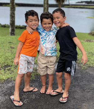 Three keiki (children) smiling for the camera